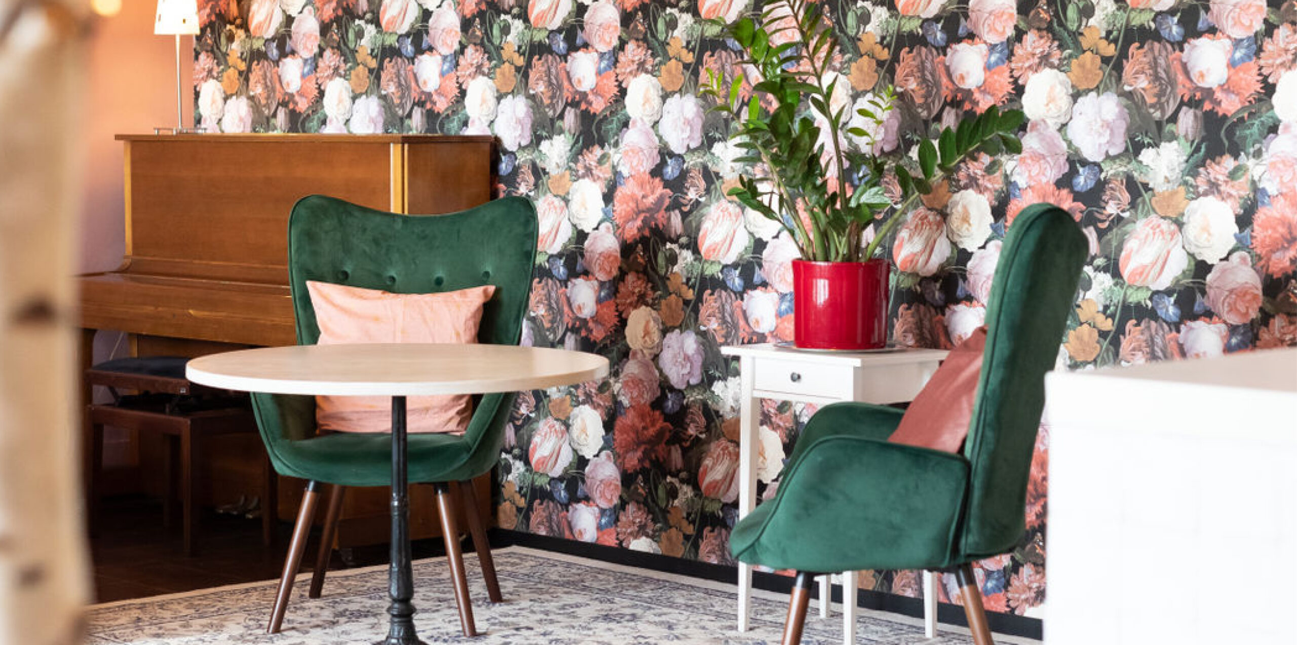 Gemütliche Sessel vor der Blumenwand in der Eventlocation